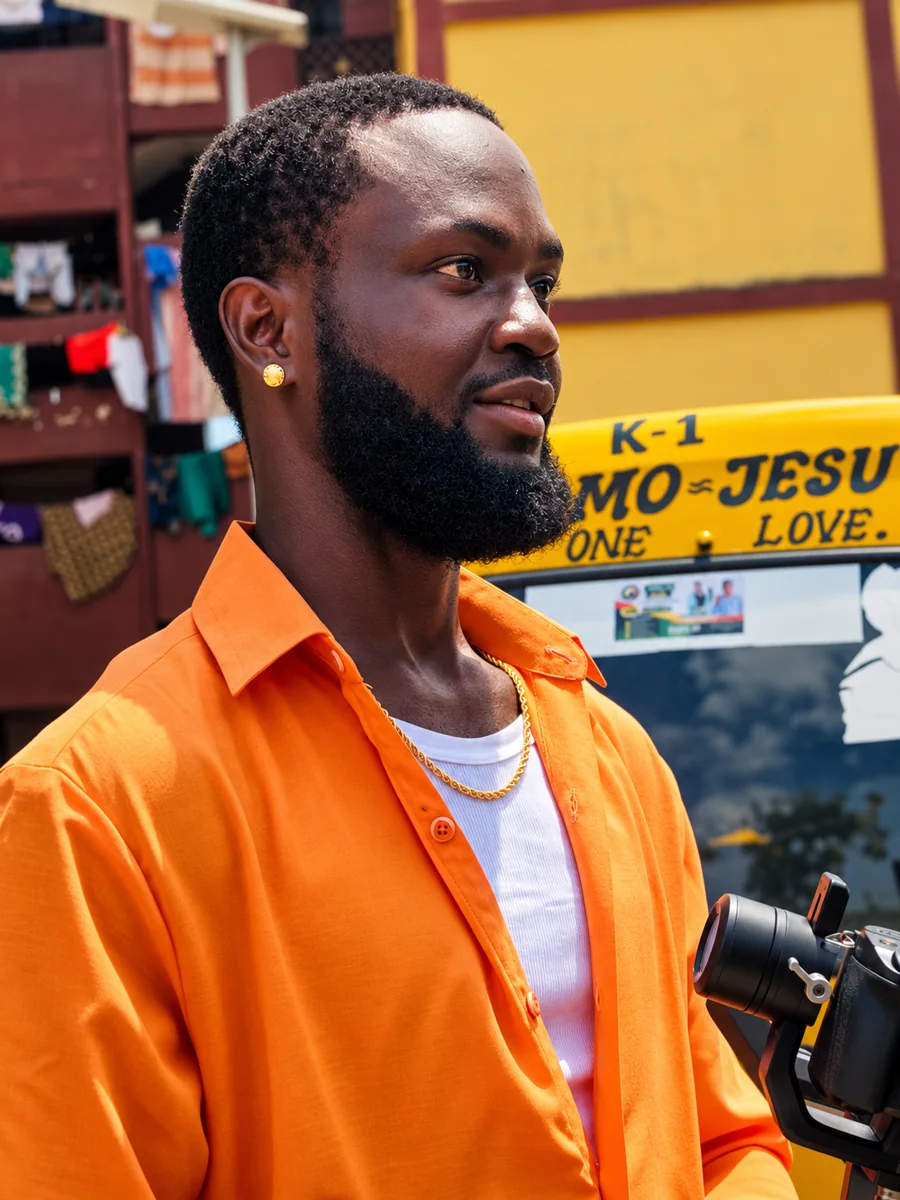 Portrait of ABIB in an orange shirt beside a yellow Lagos taxi