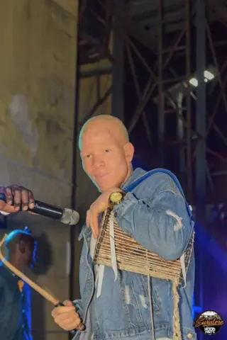 A performer in a denim jacket on stage