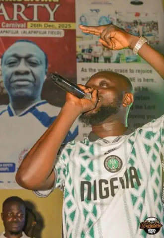 A singer performing in front of the event backdrop
